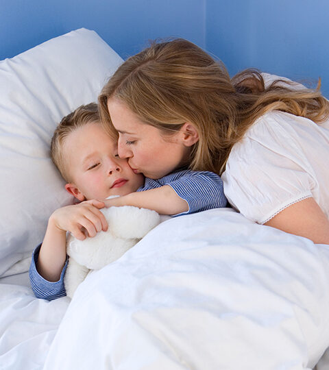 http://Mother%20kisses%20her%20sleeping%20child