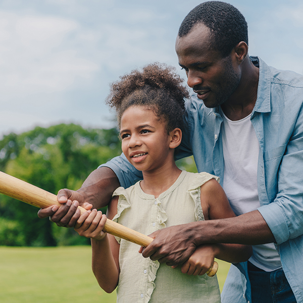 http://African%20American%20father%20helps%20his%20daughter%20swing%20a%20baseball%20bat